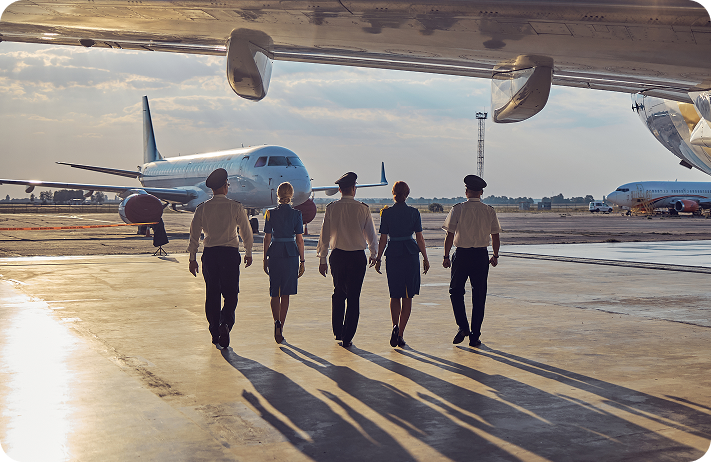 Flight crew walking across the tarmac beside a parked aircraft