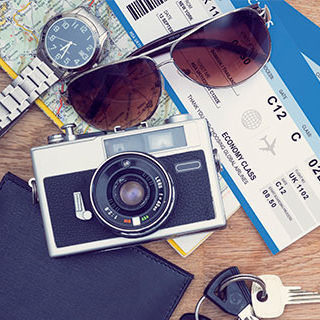 Inszone Insurance Mexico Travel Insurance Page Banner - Airplane Tickets with Travel Essentials on Table