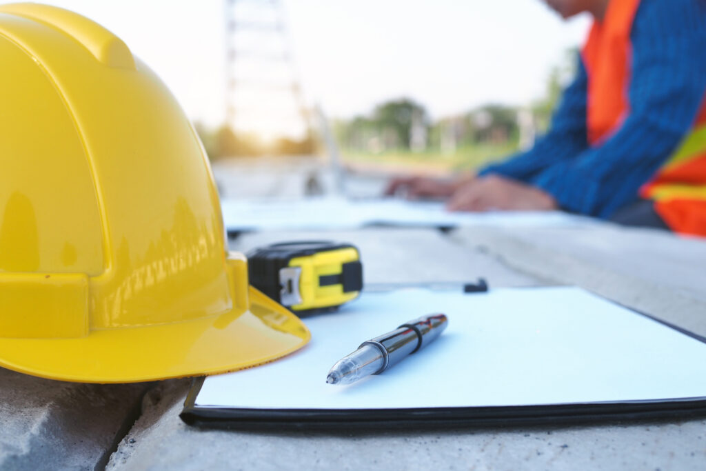 Surety bond document on a desk with a pen and hard hat in the background, representing the various types of contract bonds in construction."