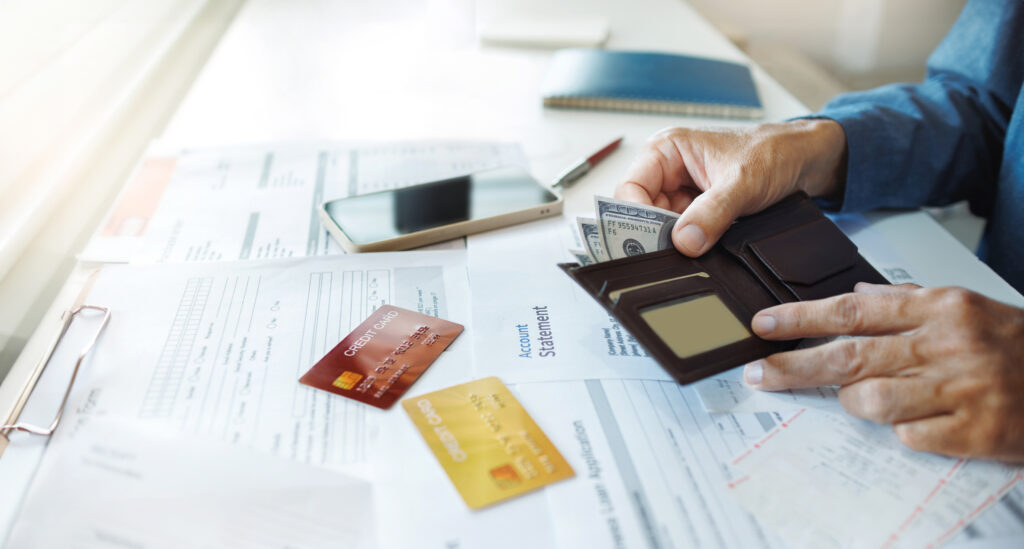 Hands holding a credit card and an account statement, symbolizing financial management and credit monitoring