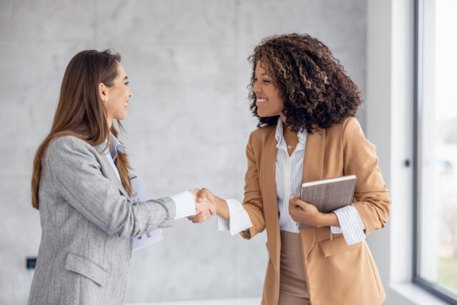 Handshake between two professionals with diverse backgrounds, indicating varied agreements and obligations.