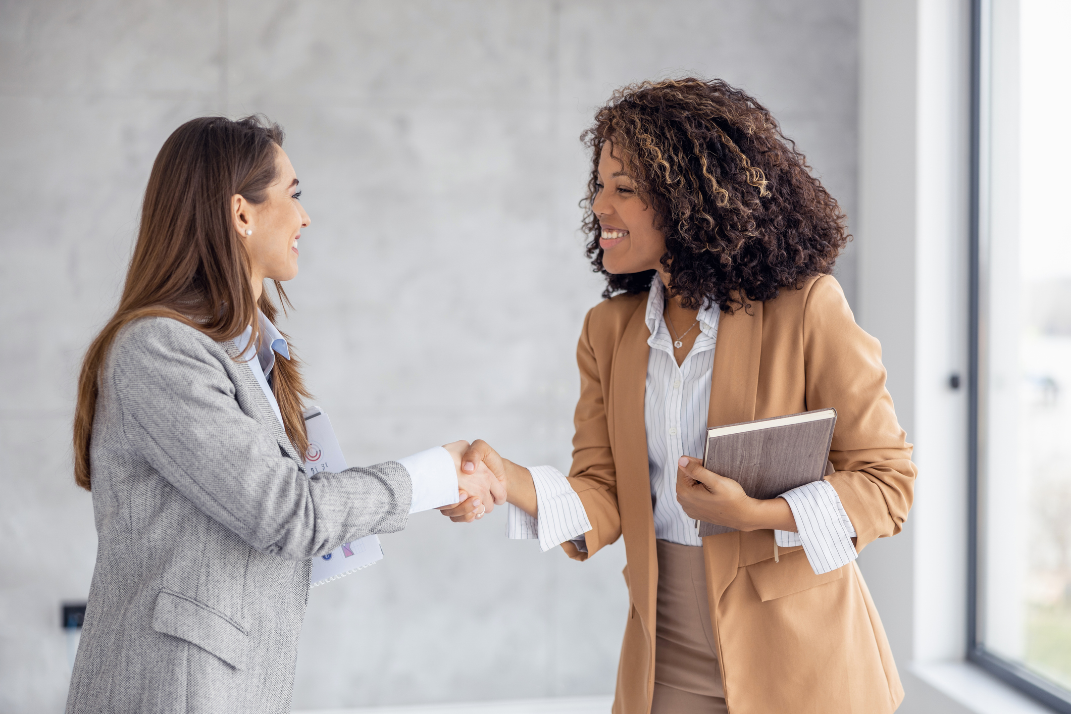 Handshake between two professionals with diverse backgrounds, indicating varied agreements and obligations.